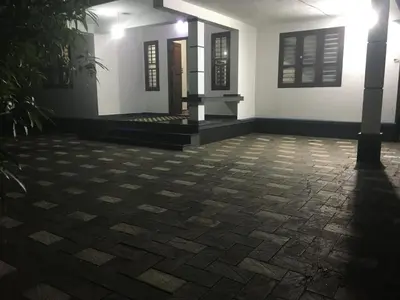 a room with a stone floor in front of a building at Peaceful perch in Kozhikode