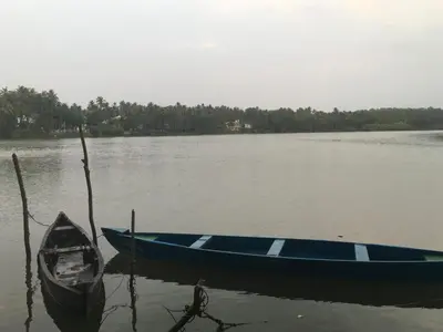 two boats sitting in the water on a lake at Peaceful perch in Kozhikode