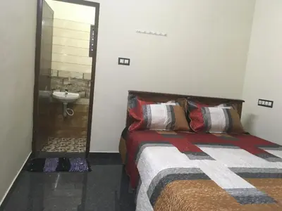 a bedroom with a bed and a bathroom with a sink at Peaceful perch in Kozhikode
