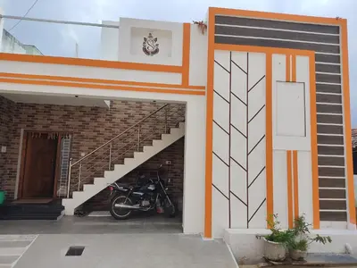 a motorcycle parked next to a building with a staircase at Jeevakanthan Home Stay in Alāndurai