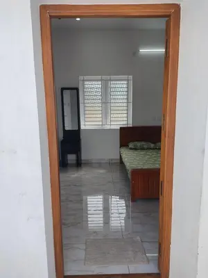 a door into a bedroom with a bed and a mirror at Jeevakanthan Home Stay in Alāndurai