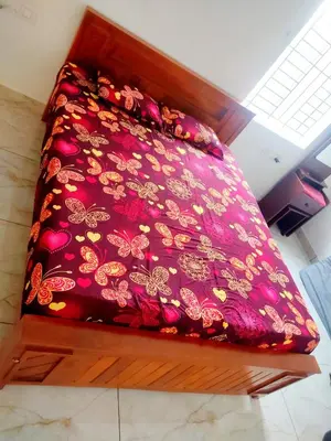a bed with a red blanket with butterflies on it at Jeevakanthan Home Stay in Alāndurai