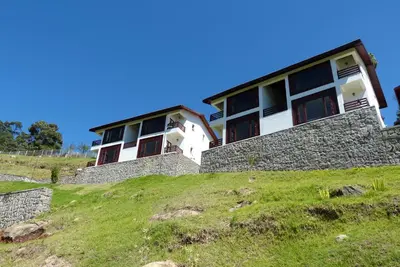 a building on top of a grassy hill at GReaT Trails Kodaikanal by GRT Hotels in Kodaikānāl