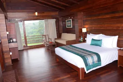 a bedroom with a large bed and a balcony at GReaT Trails Kodaikanal by GRT Hotels in Kodaikānāl