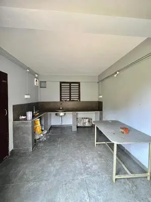 an empty kitchen with a table in a room at Kosher Livings Holiday in Kalpetta