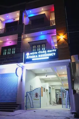 a building with a sign on the front of it at Athira Residency Coorg in Kushālnagar
