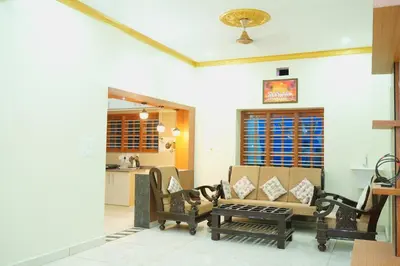 a living room with a couch and chairs and a table at Athira Residency Coorg in Kushālnagar