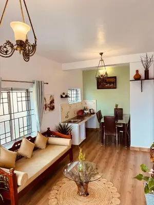 a living room with a couch and a table at Urban Lush in Ooty