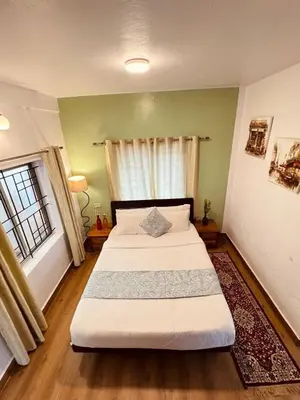 a bedroom with two beds and a window at Urban Lush in Ooty