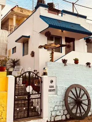a white house with a gate and a cannon at Urban Lush in Ooty