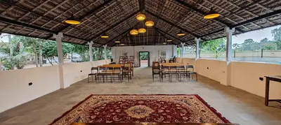 a large room with tables and chairs and a rug at Moonrise Kingdom Permaculture Farm Stay in Hura