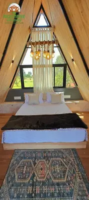 a bedroom with a large bed in a attic at Moonrise Kingdom Permaculture Farm Stay in Hura