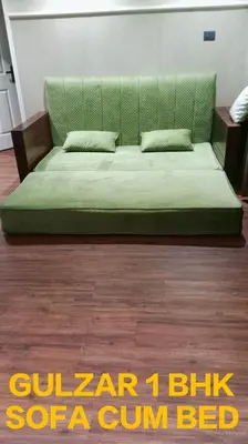 a green couch sitting on top of a wooden floor at Gulzar 1BHK Service Apartment, kannur in Kannur