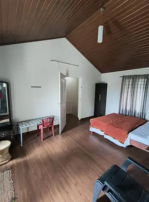 a large bedroom with a bed and a wooden ceiling at FN's Eternia in Ooty