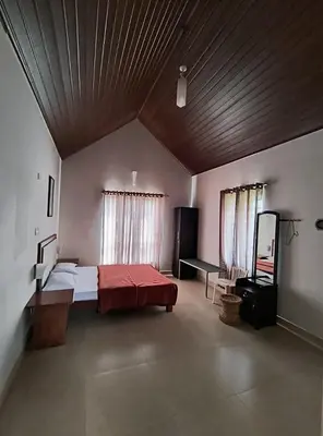 a large bedroom with a bed and a wooden ceiling at FN's Eternia in Ooty