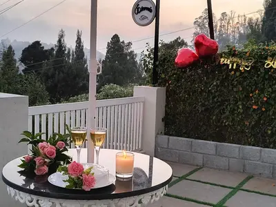 a table with two glasses of champagne and flowers at FN's Eternia in Ooty