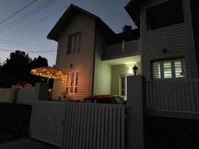 a house with a white fence in front of it at FN's Eternia in Ooty