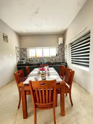 a dining room with a wooden table and chairs at blackdotstay-olive villa in Kodaikānāl