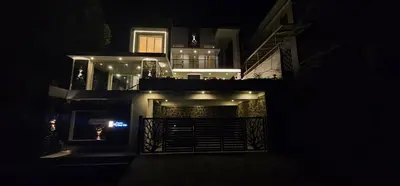 a night view of a house with lights on it at blackdotstay-olive villa in Kodaikānāl