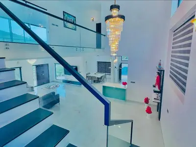 a staircase in a house with a chandelier at KiwiOz Villa in Thamarassery