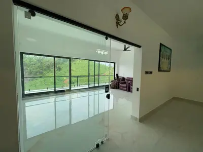 a room with a large window in a house at KiwiOz Villa in Thamarassery