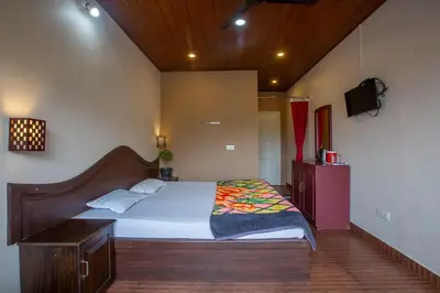 a bedroom with a bed and a tv in it at Misty Creek Homestay in Vālpārai