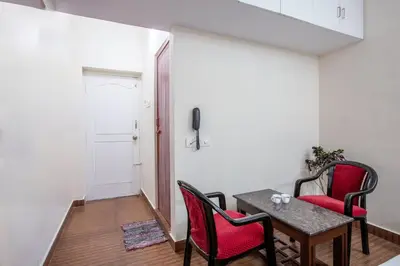 a room with a table and chairs and a television at Misty Creek Homestay in Vālpārai