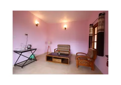 a living room with two chairs and a table at The Forest Haven in Ooty