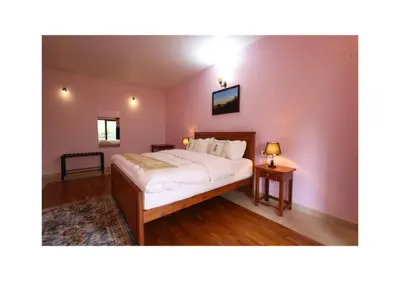 a bedroom with a large bed and two tables at The Forest Haven in Ooty