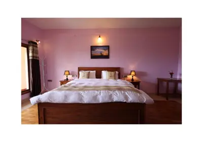 a bedroom with a large bed with two night stands at The Forest Haven in Ooty