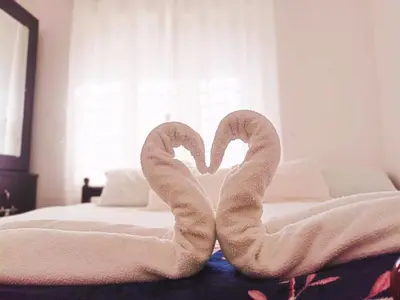 two towel swans sitting on top of a bed at Boganvilla, Magic Land Resort in Athirappilly