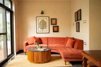 a living room with an orange couch and a table at Villa Vani in Mysore
