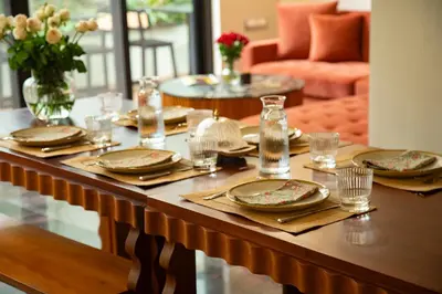a wooden table with plates and glasses on it at Villa Vani in Mysore