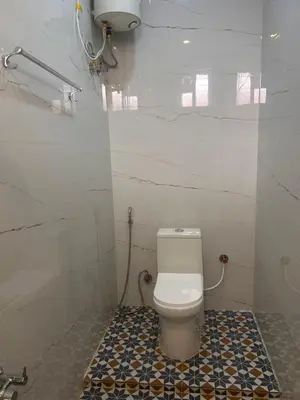 a bathroom with a toilet and a tiled floor at Rio Grande Retreat in Kodaikānāl