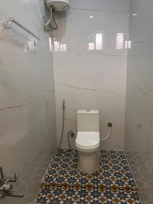 a bathroom with a toilet and a tiled floor at Rio Grande Retreat in Kodaikānāl