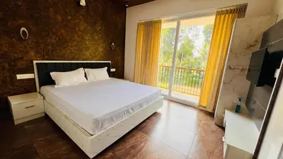 a bedroom with a bed and a large window at Wayanad Haven Villa in Wayanad