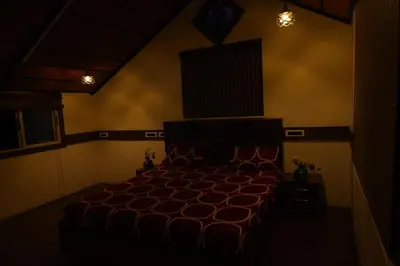 a bedroom with a bed in a dark room at SS Farms By Shivalaya Stays in Alāndurai