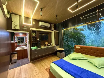 a bedroom with a bed and a large window at JOHNS VILLAGE Resorts in Vallikavungal