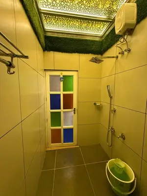 a bathroom with a window and a shower at JOHNS VILLAGE Resorts in Vallikavungal