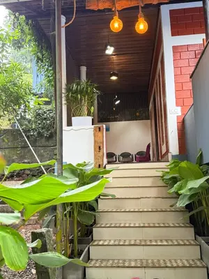 a set of stairs leading to a building with plants at JOHNS VILLAGE Resorts in Vallikavungal