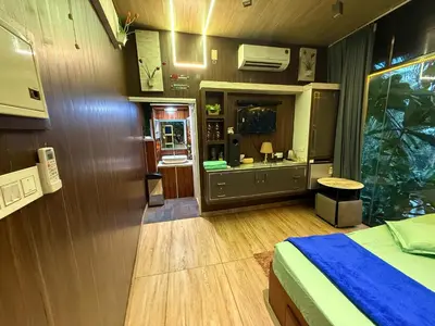 a bedroom with a bed and a bathroom with a sink at JOHNS VILLAGE Resorts in Vallikavungal