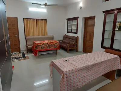 a living room with a table and a couch and chairs at Real Estate GURUVAYOOR in Trichūr