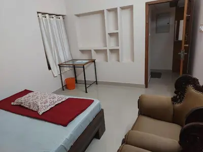 a bedroom with a bed and a couch and a chair at Real Estate GURUVAYOOR in Trichūr