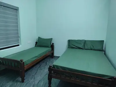 two twin beds in a room with blue walls at Green wayanad homestay in Kenichira