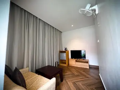 a living room with a couch and a television at Talenresort Vythiri Villas in Wayanad