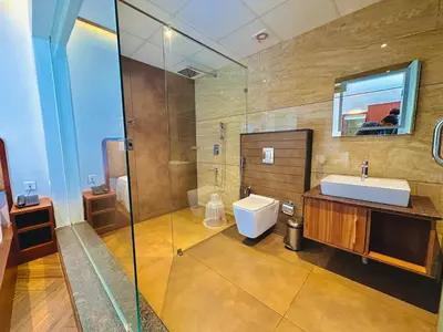 a bathroom with a sink and a toilet and a shower at Talenresort Vythiri Villas in Wayanad