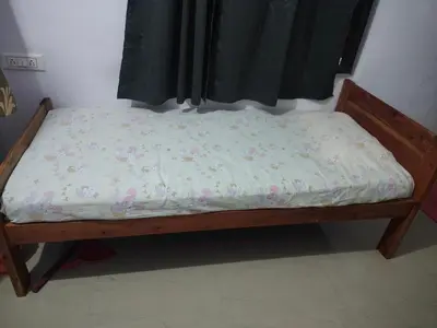 a bed in a room with a mattress with flowers on it at Aswathy Bhavan in Vadakkāncheri