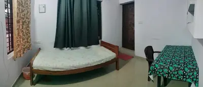 a small bedroom with a bed and a table at Aswathy Bhavan in Vadakkāncheri