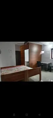 a room with a wooden table and a bench at Aswathy Bhavan in Palakkad
