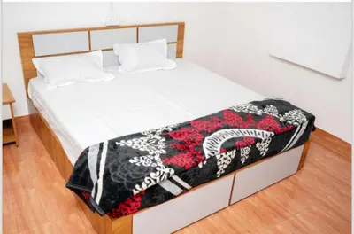 a white bed with a black and white blanket on it at Cardamom Garden Homestay Meppadi Wayanad in Meppādi